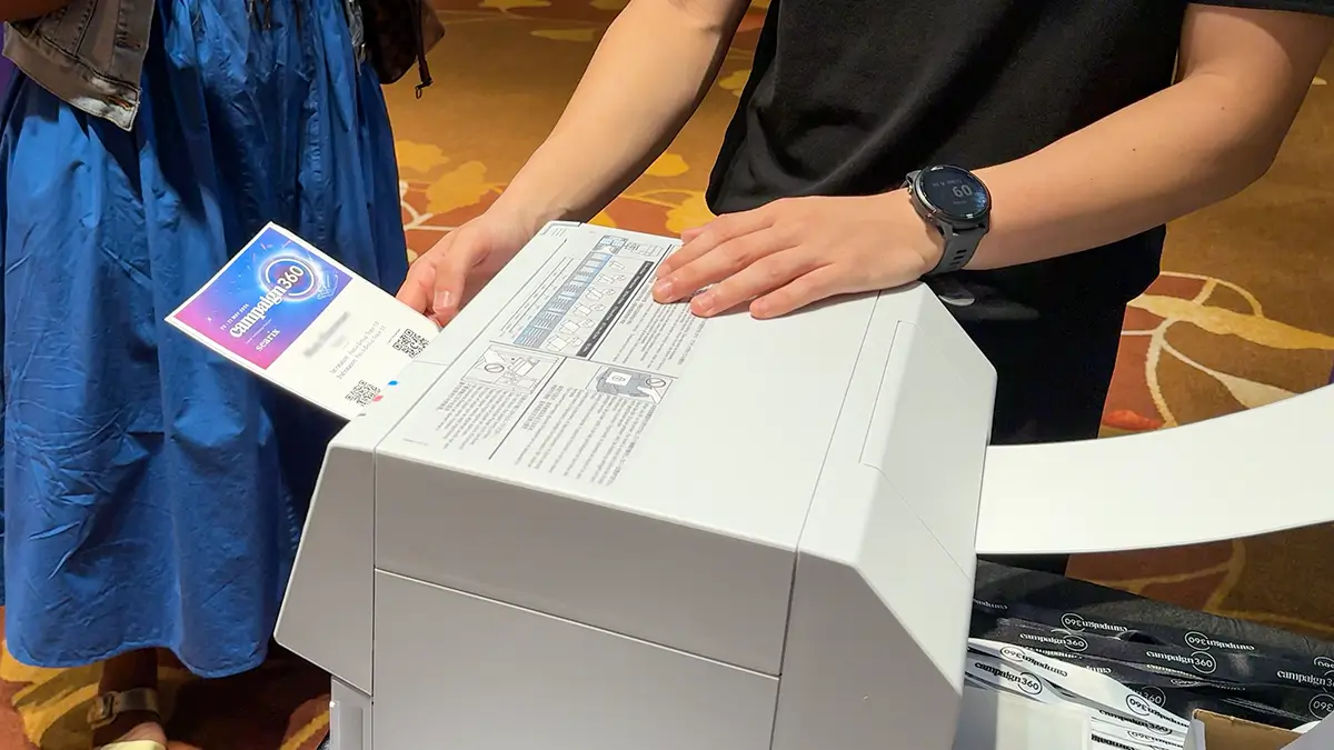 Full-colour event badge being printed from blank badge stock
