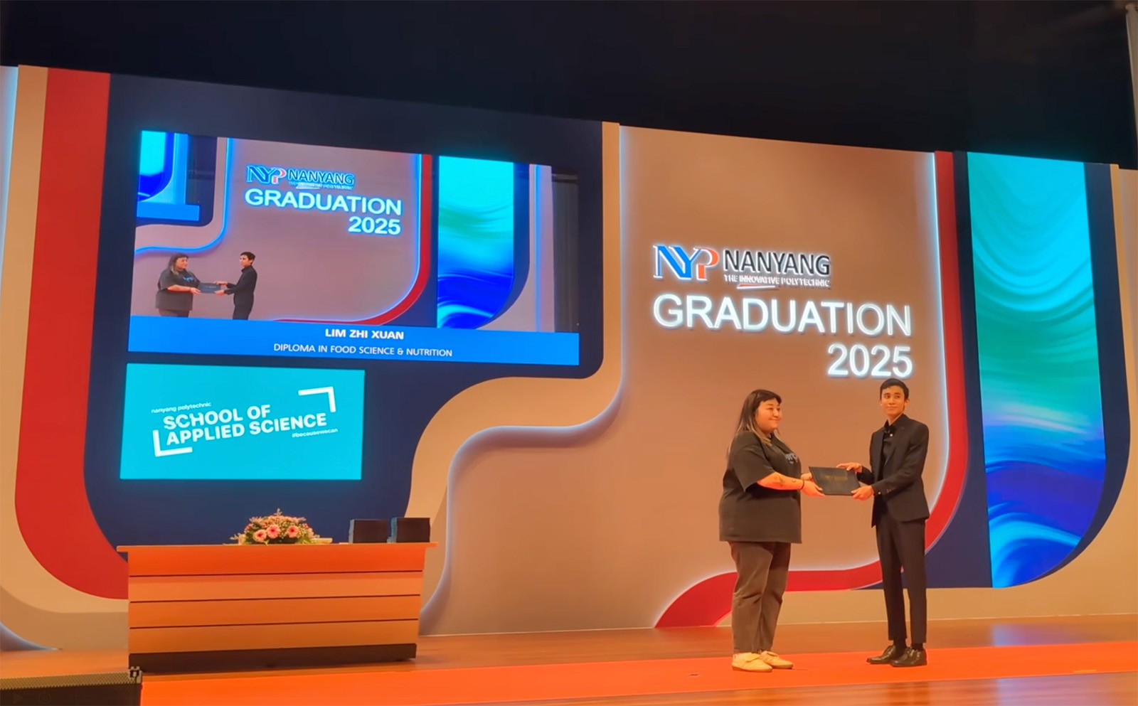The stage screen — a recipient's name shown as a lower-third over the live camera feed