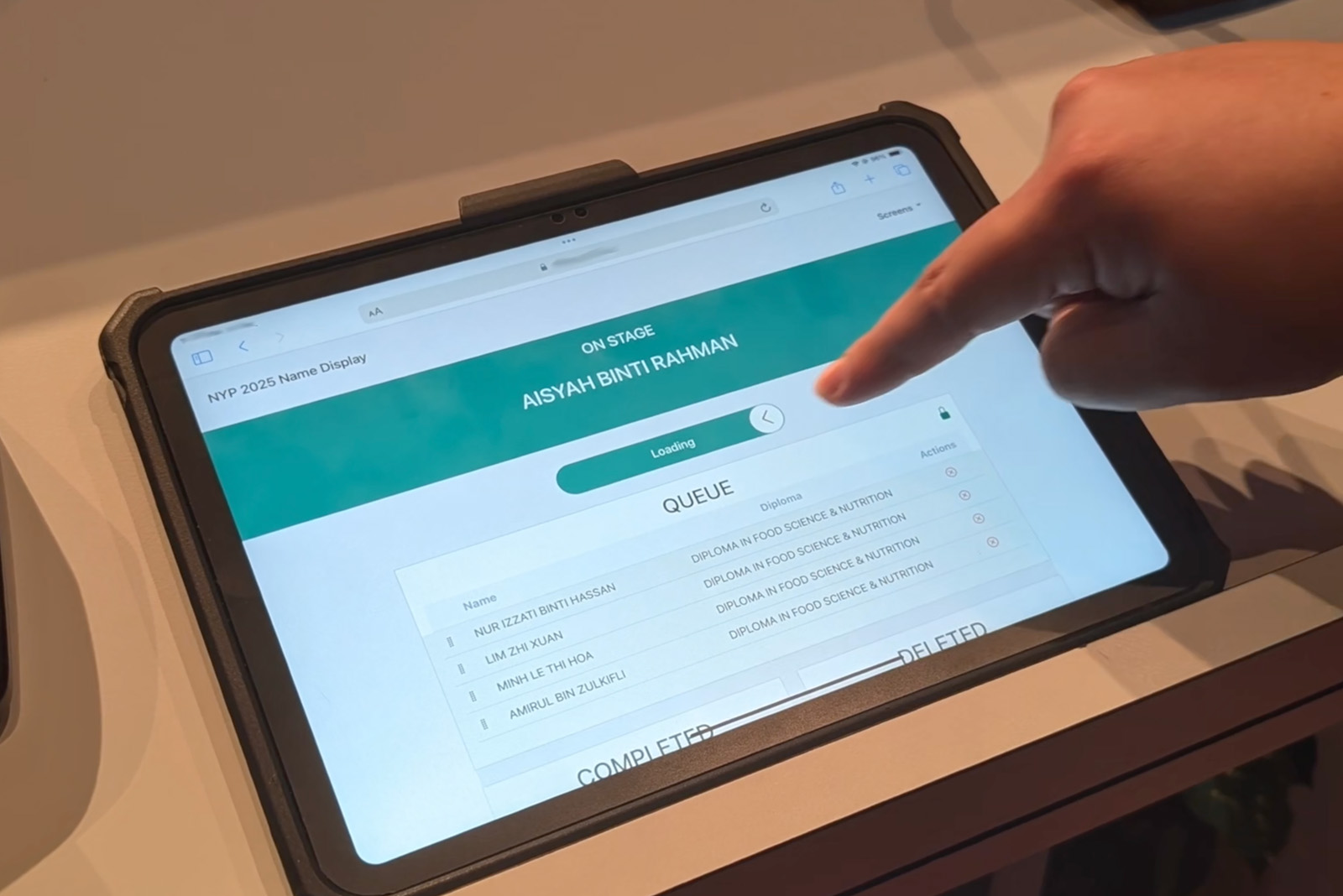 The control tablet — swiping to call the next name from the queue